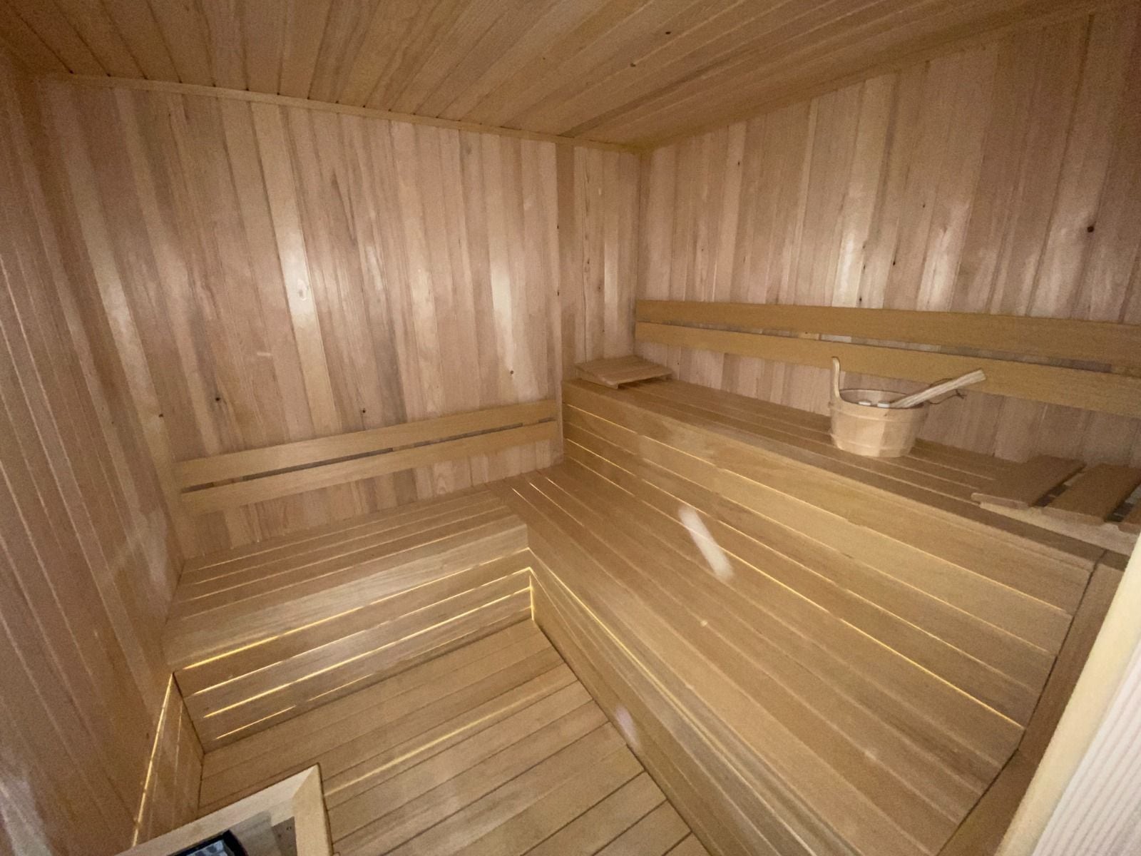 Bornova özel sauna, ahşap kaplamalı kabin ve kademeli oturma sıraları