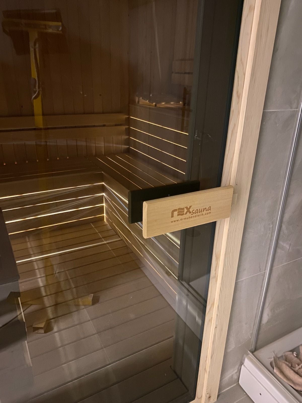 Bornova özel sauna, cam kapı ve rexsauna logolu kapı kolu