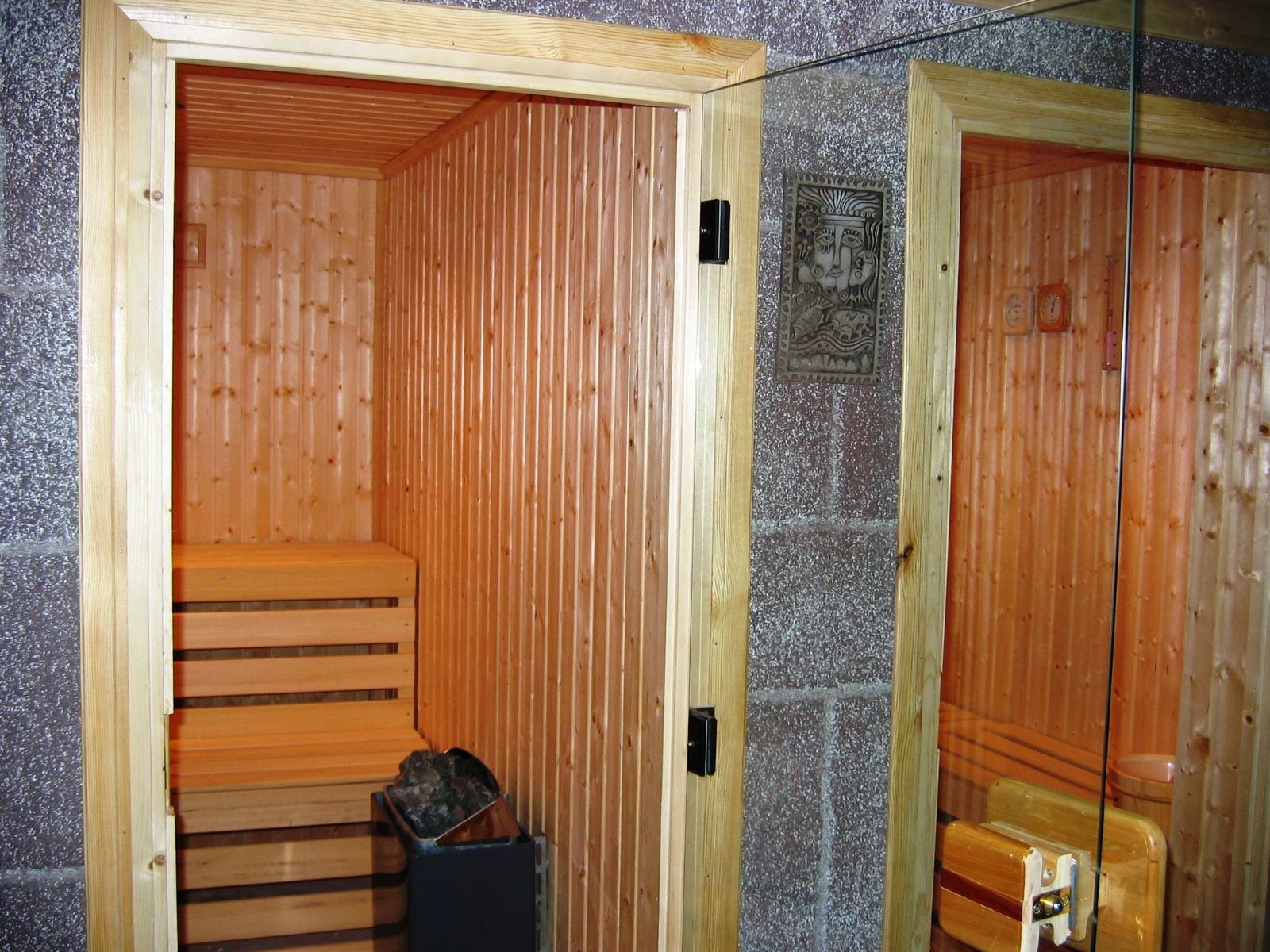 Ahşap sauna kabininin içi, kademeli sıralar ve elektrikli soba