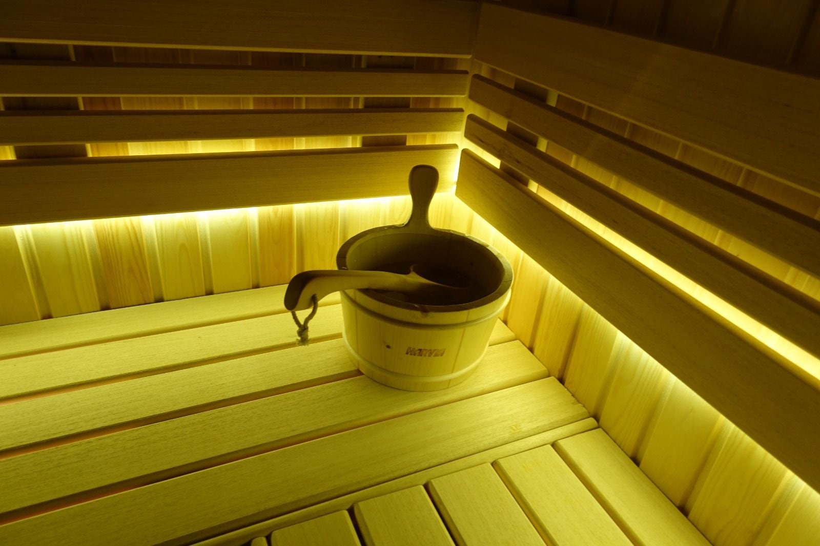 Urla özel sauna, LED ile aydınlatılmış ahşap sıralar ve sauna kovası